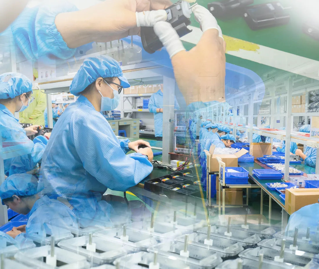 The Shenzhen assembly line in blue coveralls, hairnets and gloves, building devices at the bench.